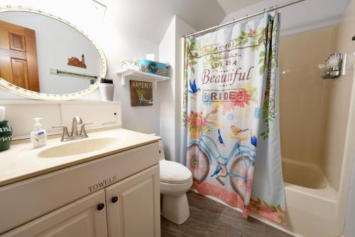 a bathroom with a sink and a toilet and a shower curtain at The Manor at Becks Lake in Rockmart