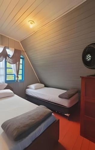 a bedroom with two beds and a window at Chalé frente mar na Ilha do Mel - Encantadas. in Ilha do Mel