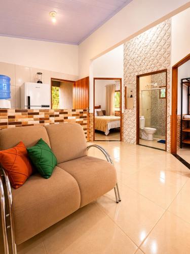 a living room with a couch with colorful pillows on it at Chalés Araras do Vale in Colinas Do Sul