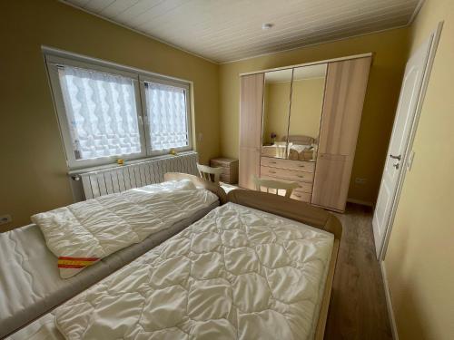 ein Schlafzimmer mit zwei Betten und einem großen Fenster in der Unterkunft Kleegarten in Eppelborn