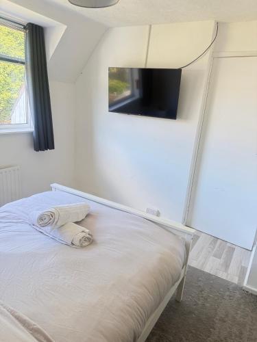 a bedroom with a bed with a tv on the wall at Families and Contractors Dudley DY1 in Lower Gornal