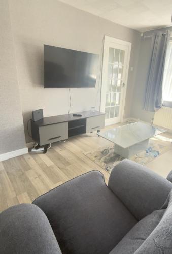 a living room with a couch and a tv at Families and Contractors Dudley DY1 in Lower Gornal