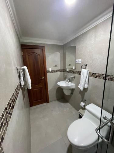 a bathroom with a toilet and a sink at Riberas del Valle in Cuenca