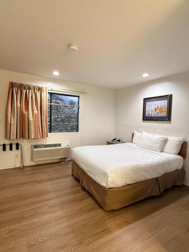 a bedroom with a large bed and a window at Jolly Roger Hotel in Los Angeles