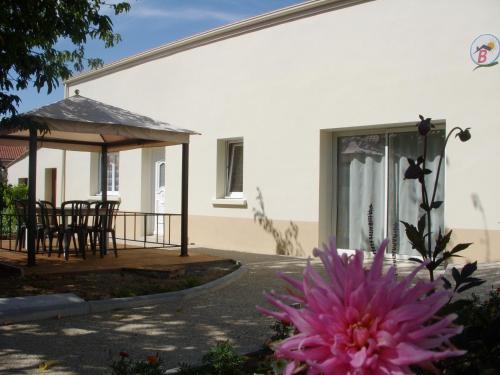 una flor rosa frente a una casa en Gîte Beaupel, en Neuvy-en-Mauges