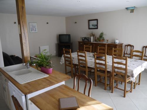 cocina y comedor con mesa y sillas en Gîte Beaupel en Neuvy-en-Mauges