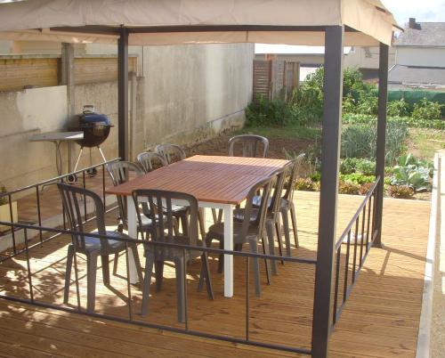 uma mesa e cadeiras sob um gazebo num deque em Gîte Beaupel em Neuvy-en-Mauges