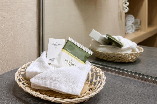 a basket of towels on a table in front of a mirror at Hotel Cortez Baja Inn, Ensenada in Ensenada