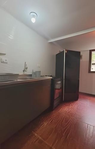 a kitchen with a black refrigerator in a room at Casa da Ale e do Thi - Ilha do Mel in Ilha do Mel