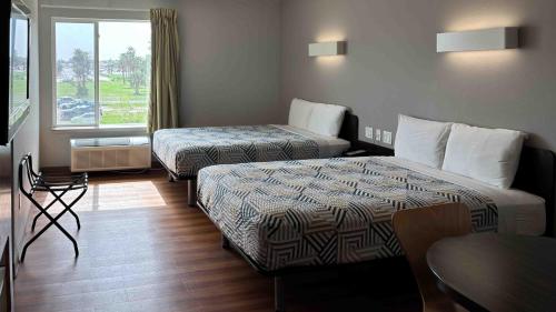 a hotel room with two beds and a window at Motel 6-Weslaco, TX in Weslaco