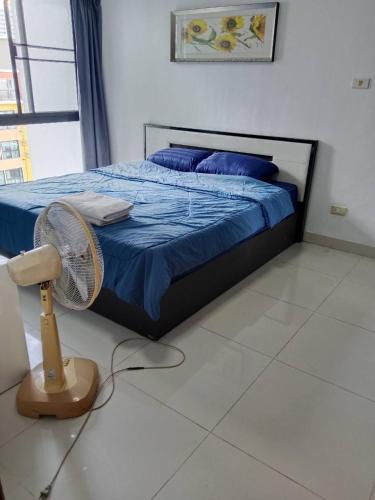 a bedroom with a bed with blue sheets and a fan at Neo2 condo 703 in Jomtien Beach