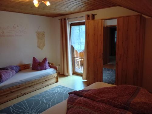 a bedroom with a bed and a large window at Ferienwohnung Steinbeisser in Arrach