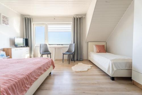 a bedroom with two beds and a desk and a window at Magdalena in Karwia