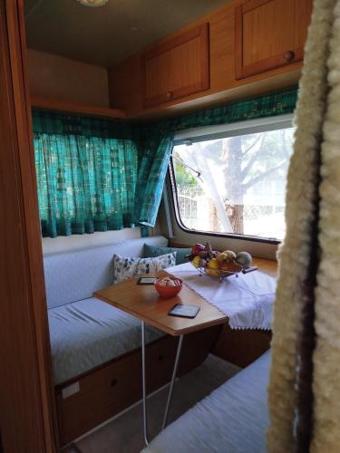a small room with a table and a bed in a train at DamAnda mare in Nea Potidaea