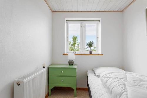 a bedroom with a green bed and a window at 6707-Ronne-Kallokkevej-5 in Rønne