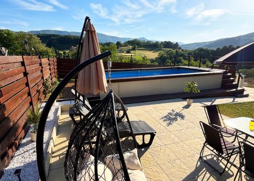 a patio with an umbrella and a swimming pool at Vila Jovanovic in Bajina Bašta