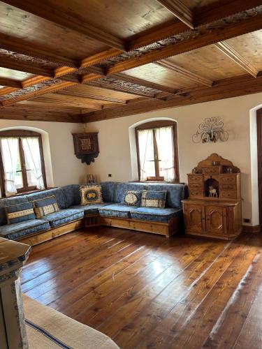 a living room with a blue couch and wooden floors at Panorama Lodge in Cortina dʼAmpezzo