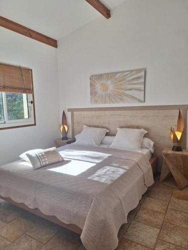 a bedroom with a large bed with two lamps at Gîte Acellu in Bonifacio