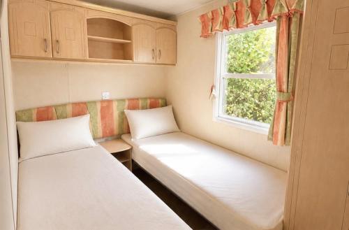 a small room with two beds and a window at Parc Montana - Mobile home in Gassin