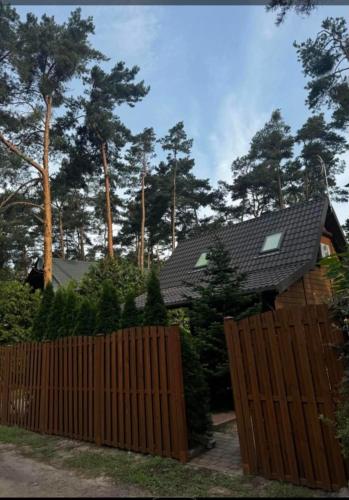 a wooden fence in front of a house with trees at Hygge in Brenno