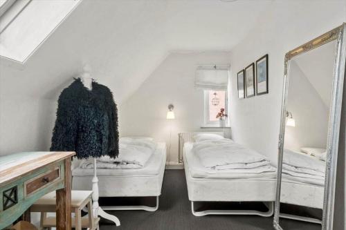 a white room with two beds and a mirror at 80320-Ulfborg-Reberbanen-4 in Ulfborg