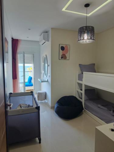 a small room with a bunk bed and a couch at Beachfront Dream, WaveHaus in Akouda