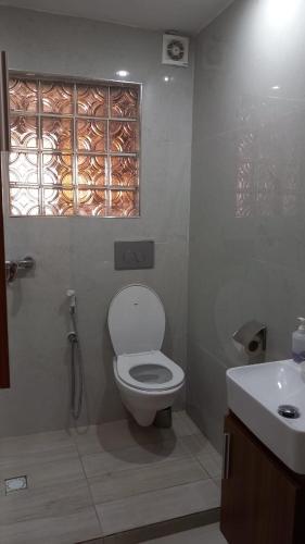 a bathroom with a toilet and a sink and a window at Elite appart in Dakar