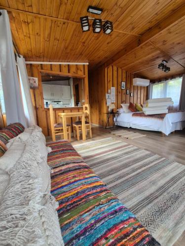 a large room with a bed and a table in it at Cabañas Carolín Cacao Castaño in San José de Maipo