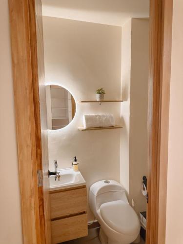 a small bathroom with a toilet and a sink at CityZen Apartahotel in Florencia