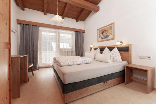 a bedroom with a large bed and a window at Appartement Gehörde-Sölden inklusive Summercard in Sölden