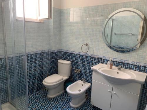 a bathroom with a toilet and a sink and a mirror at Vila Era in Shëngjin