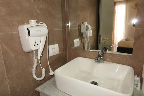 a bathroom sink with a hair dryer and a phone at Esal Hotel in Durrës