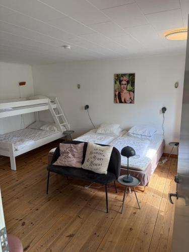 a bedroom with two bunk beds and a chair at SleepCleanGo L3 in Gnisvärd