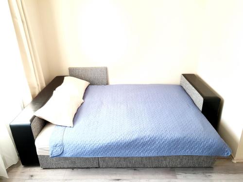 a bed with a blue mattress and a pillow at Ezerkrasts Daugavas 7 in Liepāja