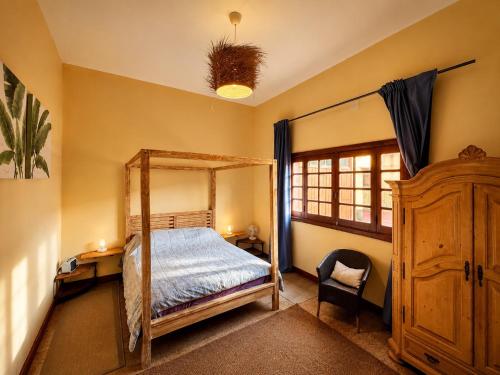 a bedroom with a canopy bed and a chair at Fort Tenerife Gran Casa de Campo in Tacoronte