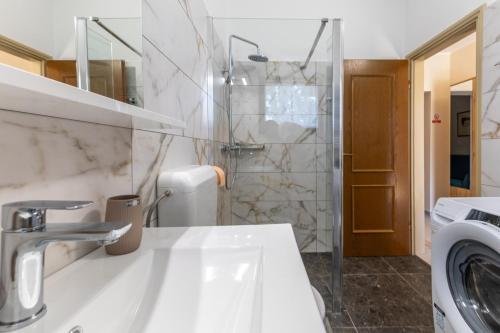 a white bathroom with a sink and a shower at Green Oasis with Terrace in Pazin