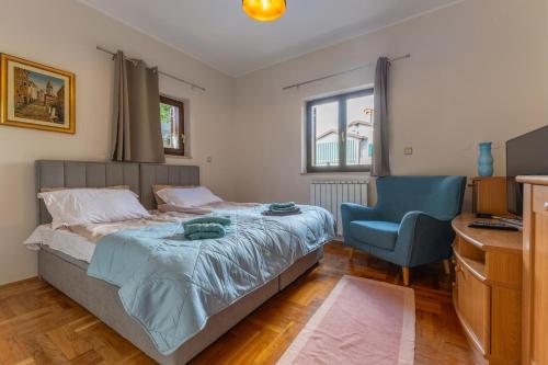 a bedroom with a bed and a blue chair at Green Oasis with Terrace in Pazin