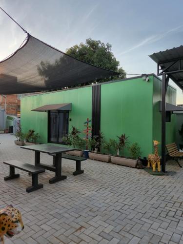 a patio with a table and a green wall at Casa Container Natureza Concept in Foz do Iguaçu