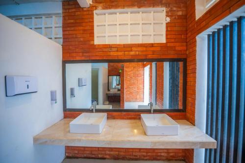 a bathroom with two sinks and a mirror at Ndalem Prabu in Sarangan