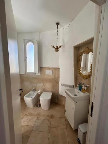 a bathroom with two sinks and a toilet and a tub at Masseria Pelosella B&B in Fasano