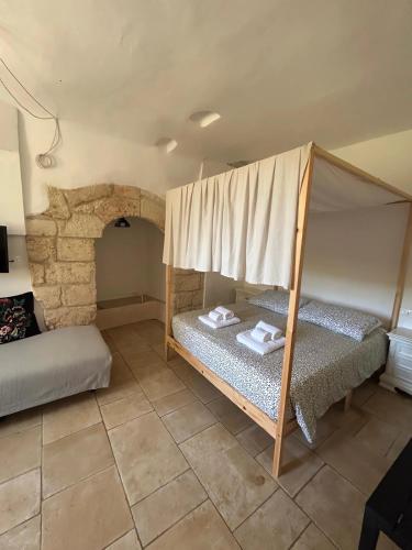 a room with two bunk beds and a stone wall at Masseria Pelosella B&B in Fasano