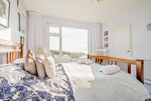 a bedroom with a large bed with a large window at 4 Bed in Tintagel oc-trev in Treknow