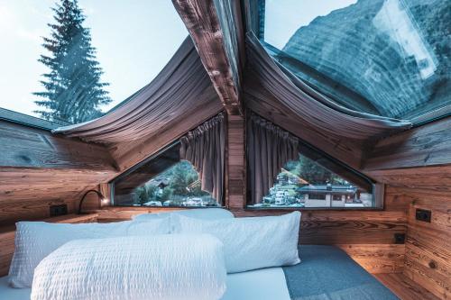 a bedroom with a bed and two windows at BergNest in Huben