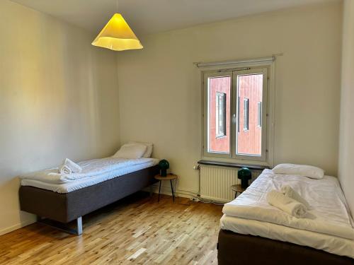 a bedroom with two beds and a window at Apartment Centrum Karlshamn in Karlshamn