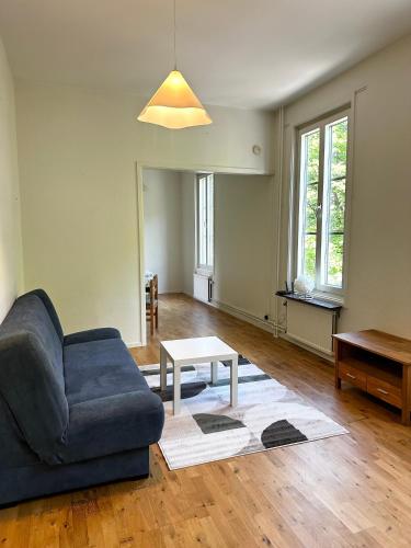 a living room with a blue couch and a table at Apartment Centrum Karlshamn in Karlshamn