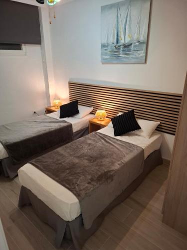 a bedroom with two beds and a sailboat on the wall at Formentor Inn in Salou
