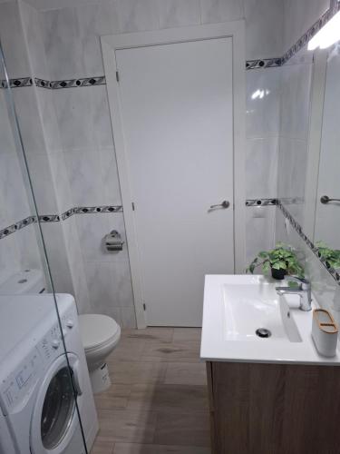 a bathroom with a sink and a washing machine at Formentor Inn in Salou