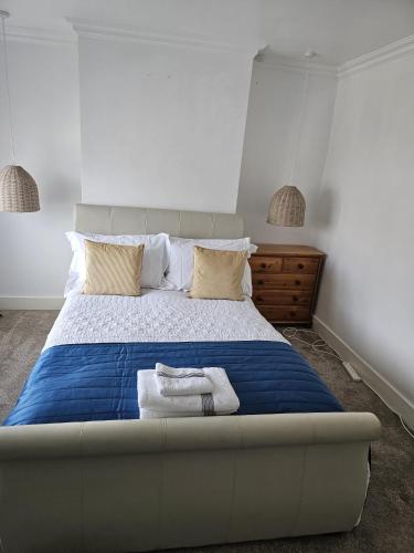 a bedroom with a large bed with towels on it at Bethel House in Kennington