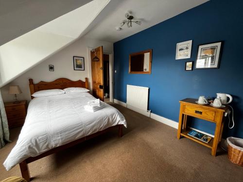 a bedroom with a bed and a blue wall at Castle Viewpoint B&B in Inverness