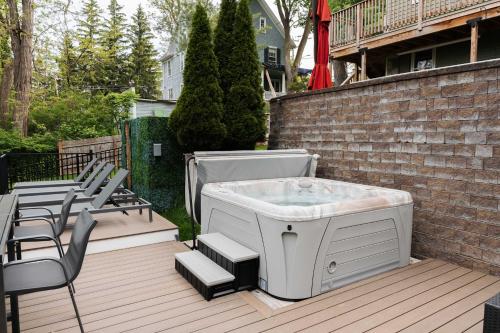 a hot tub sitting on a deck with chairs at Lakeview on Main Pool Fire Pit and Walkable in Geneva
